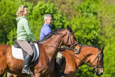 A couple horseback riding together.